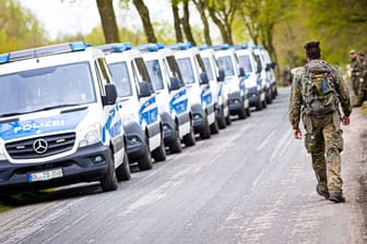 Ein Soldat der Bundeswehr geht an Einsatzfahrzeugen der Polizei vorbei (Archivfoto): Für die Polizei sei es aktuell ein "ganz zähes Ermitteln", sagte ein Sprecher.