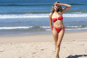 Smiling woman in red bikini posing on a sunny beach. Huntington Beach, California, United States R_RILV240423-1409633-01 ,model released, Symbolfoto