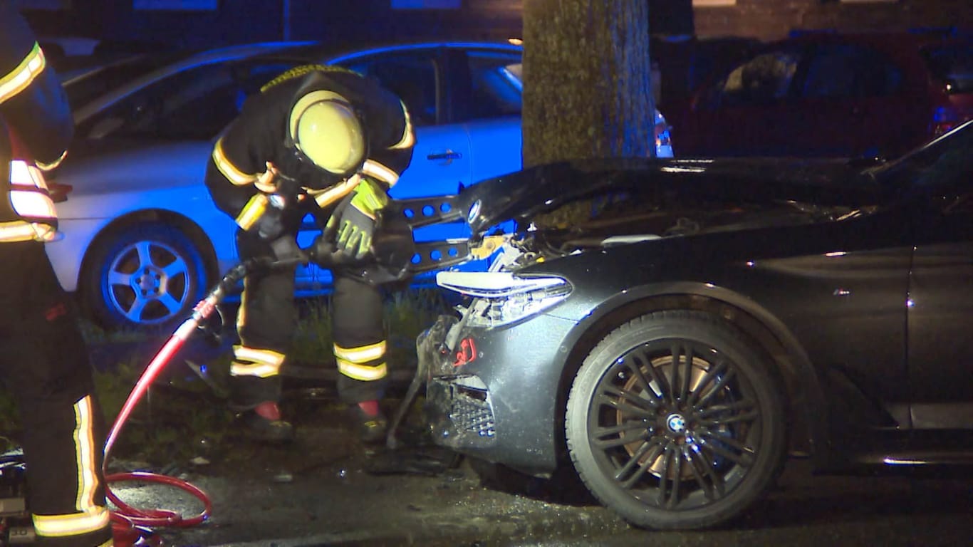 Ein Feuerwehrmann überprüft das verunfallte Auto: Der Dieb raste gegen Leitpfosten und dann in zwei geparkte Autos.