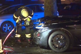 Ein Feuerwehrmann überprüft das verunfallte Auto: Der Dieb raste gegen Leitpfosten und dann in zwei geparkte Autos.
