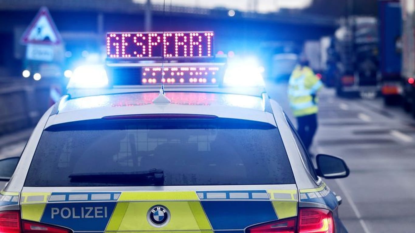 Auf einem Polizeifahrzeug leuchtet die Aufschrift "Gesperrt": Weil die Fahrbahn abgesackt ist, kann ein Teil der A3 nicht befahren werden.