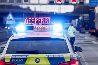 Auf einem Polizeifahrzeug leuchtet die Aufschrift "Gesperrt": Weil die Fahrbahn abgesackt ist, kann ein Teil der A3 nicht befahren werden.