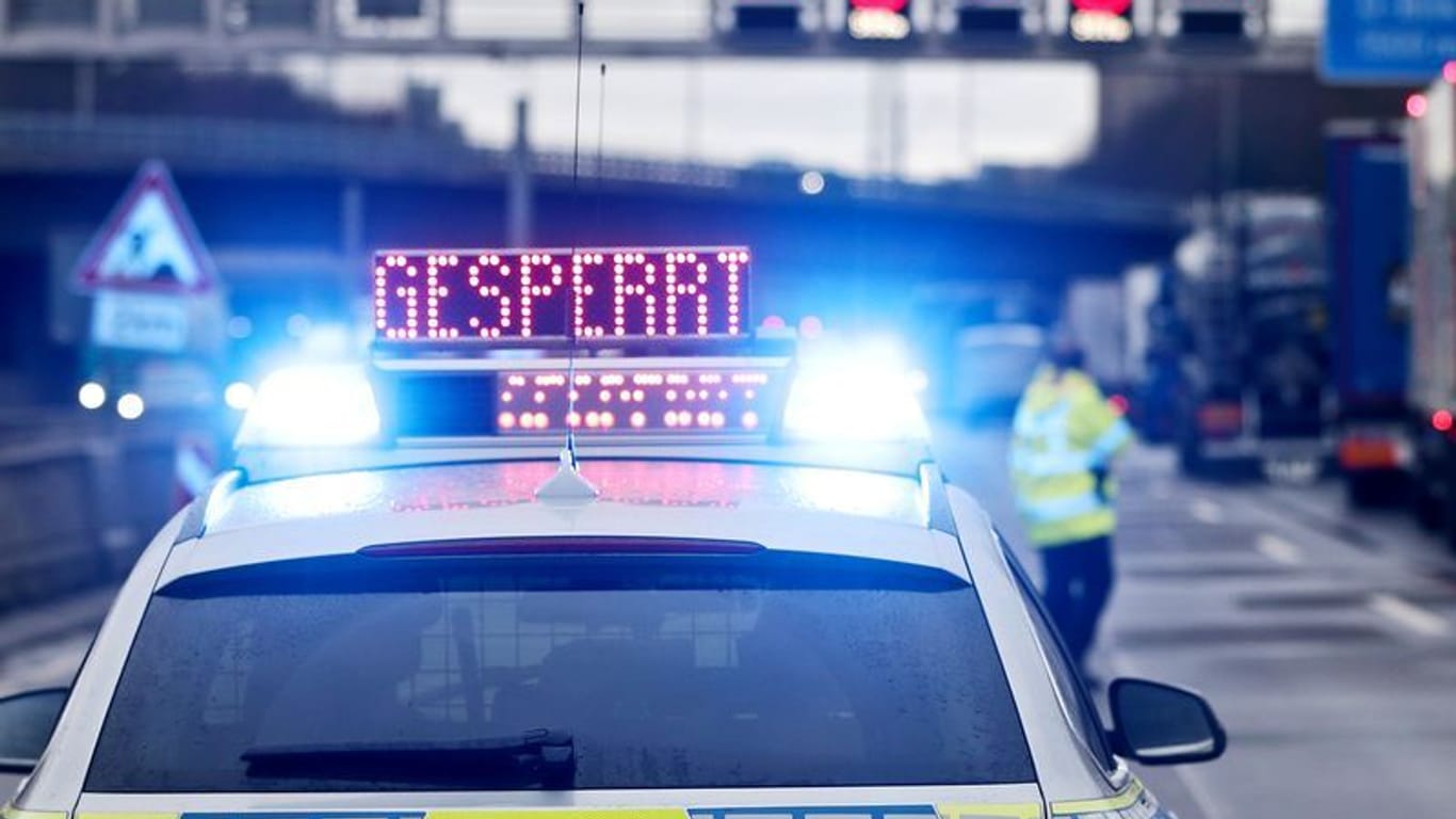 Auf einem Polizeifahrzeug leuchtet die Aufschrift "Gesperrt": Weil die Fahrbahn abgesackt ist, kann ein Teil der A3 nicht befahren werden.