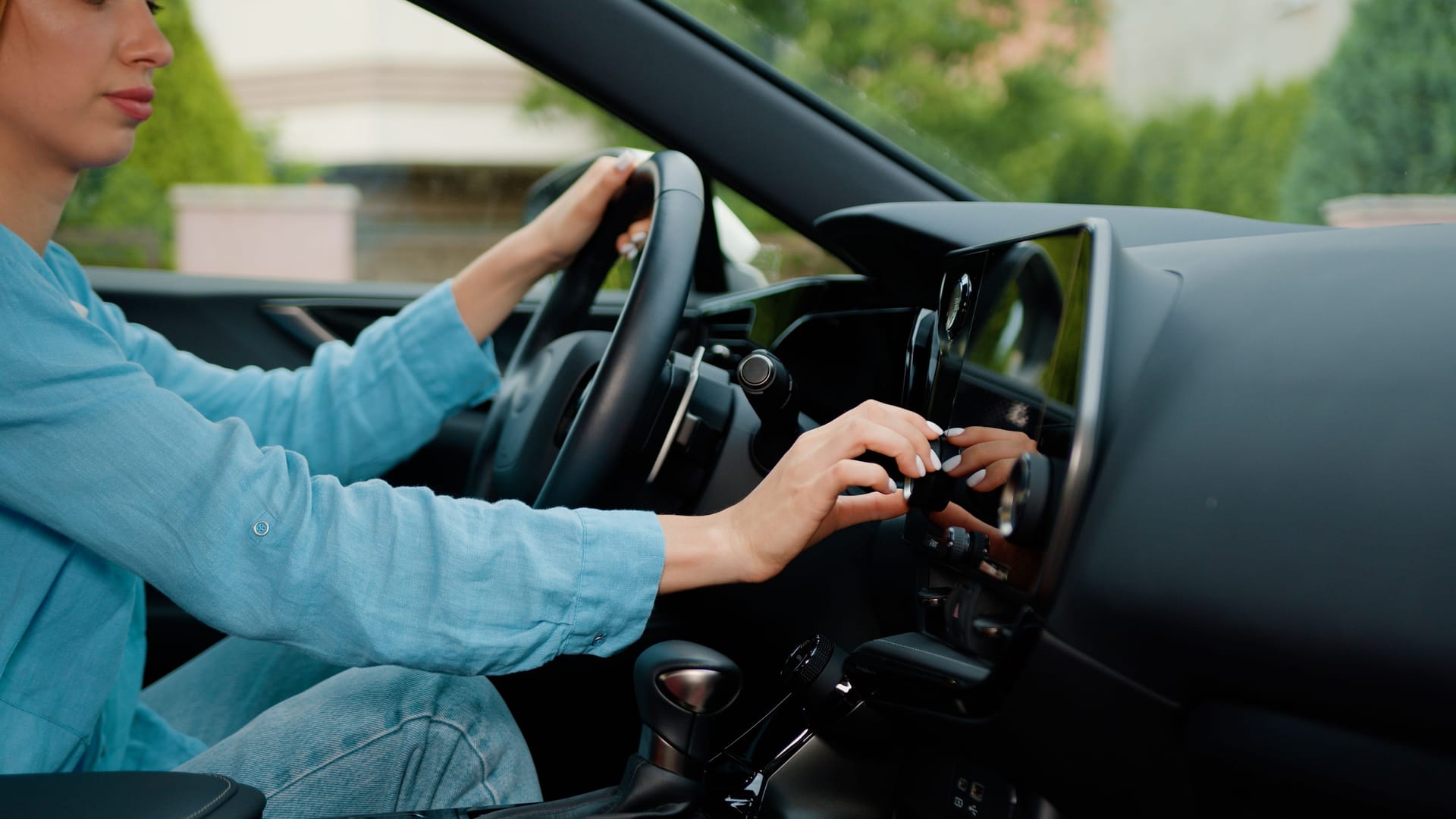 Close up shot hand of woman using touch screen in car setting up the navigation gps application on the touchscreen console.