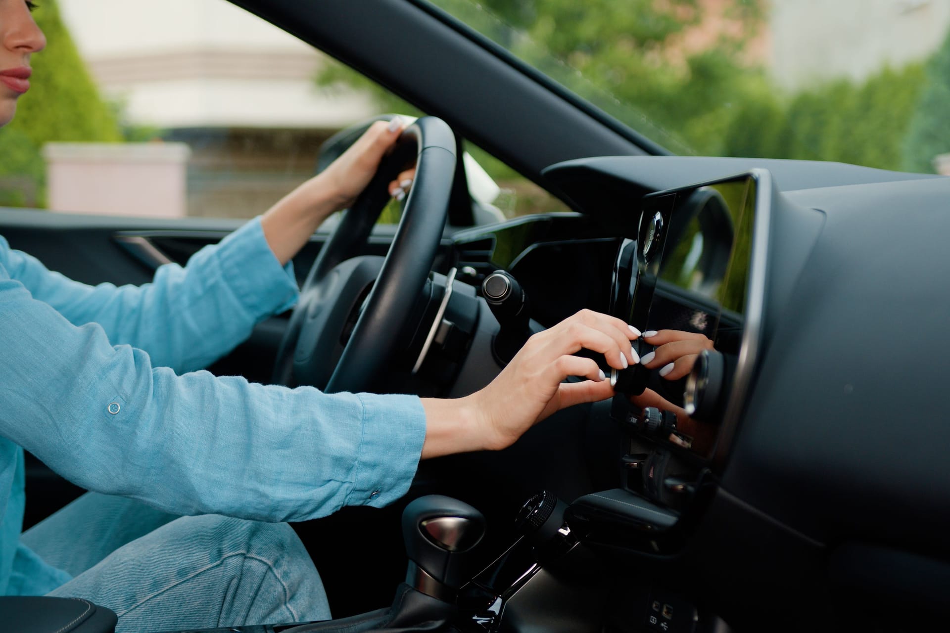 Close up shot hand of woman using touch screen in car setting up the navigation gps application on the touchscreen console.