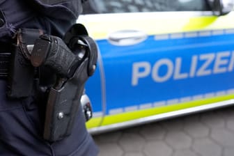 Ein Polizist steht vor einem Einsatzfahrzeug der Polizei: In Hamburg sind die Straftaten im ersten Quartal um 12,4 Prozent zurückgegangen.