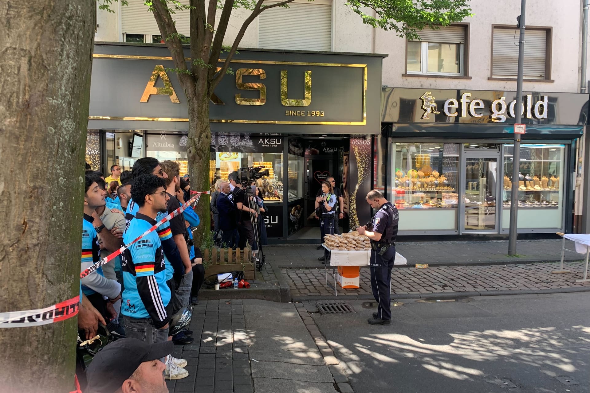 Besucher hinter einem Absperrband auf der Keupstraße: Die Polizei ist mit Spürhunden im Einsatz.