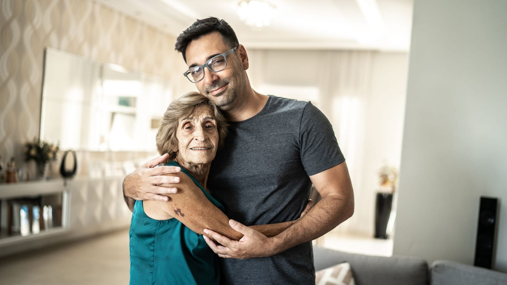 Sohn und Mutter umarmen sich: Wer ausreichend verdient, kann vom Staat zur Kasse gebeten werden, wenn die Eltern ins Pflegeheim kommen.