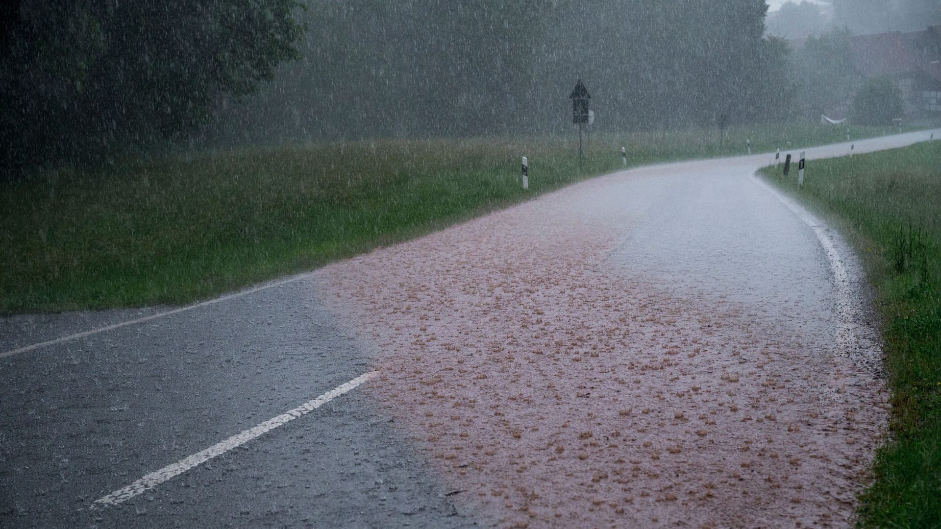 Thüringen, Hildburghausen: Das Regenwasser spült Erde über eine Straße.