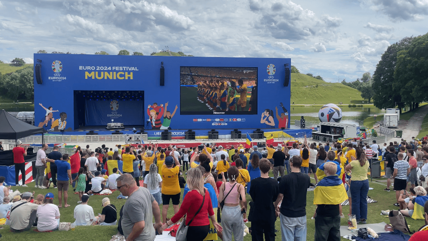 Bei sommerlichen 25 Grad verfolgen Fans die Partie zwischen der Ukraine und Rumänien. Nach den Nationalhymnen gibt es für beide Teams respektvollen Applaus.