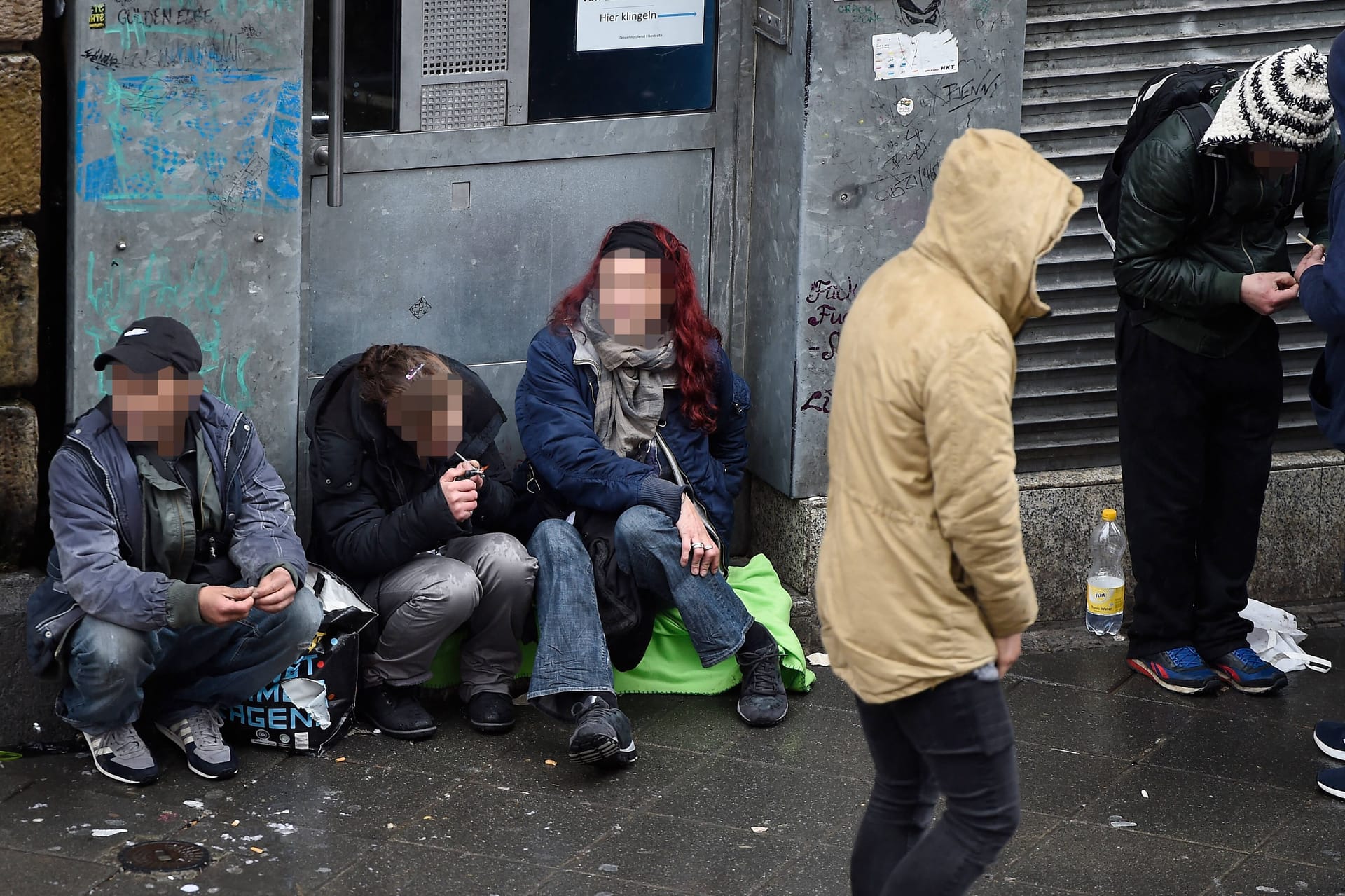 Dealer und Drogen-Konsumenten sitzen vor dem Drogennotdienst in Frankfurt am Main (Archivbild).