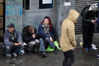 Dealer und Drogen-Konsumenten sitzen vor dem Drogennotdienst in Frankfurt am Main (Archivbild).