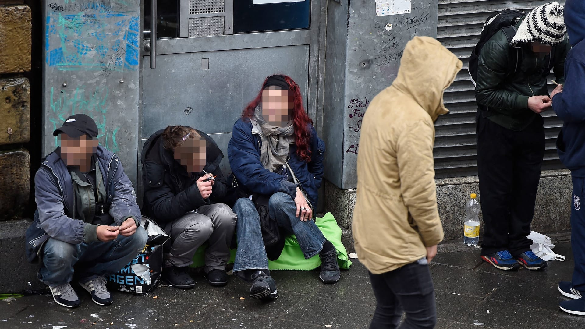 Dealer und Drogen-Konsumenten sitzen vor dem Drogennotdienst in Frankfurt am Main (Archivbild).