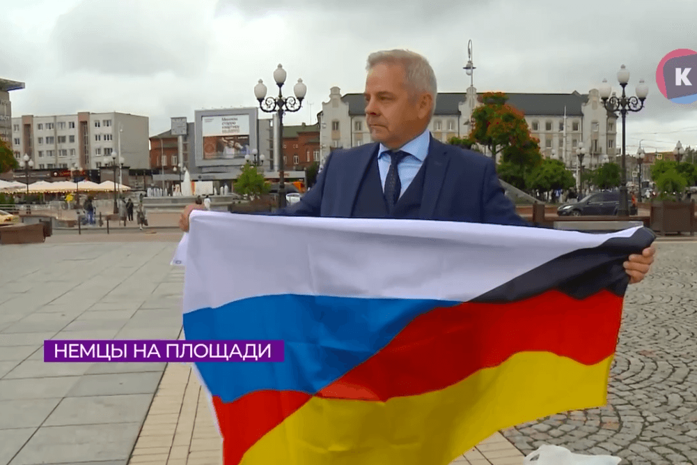 Deutsch-russische Flagge hoch: Der AfD-Abgeordnete Frank Lizureck auf dem Siegesplatz in Kaliningrad - und im russischen TV.