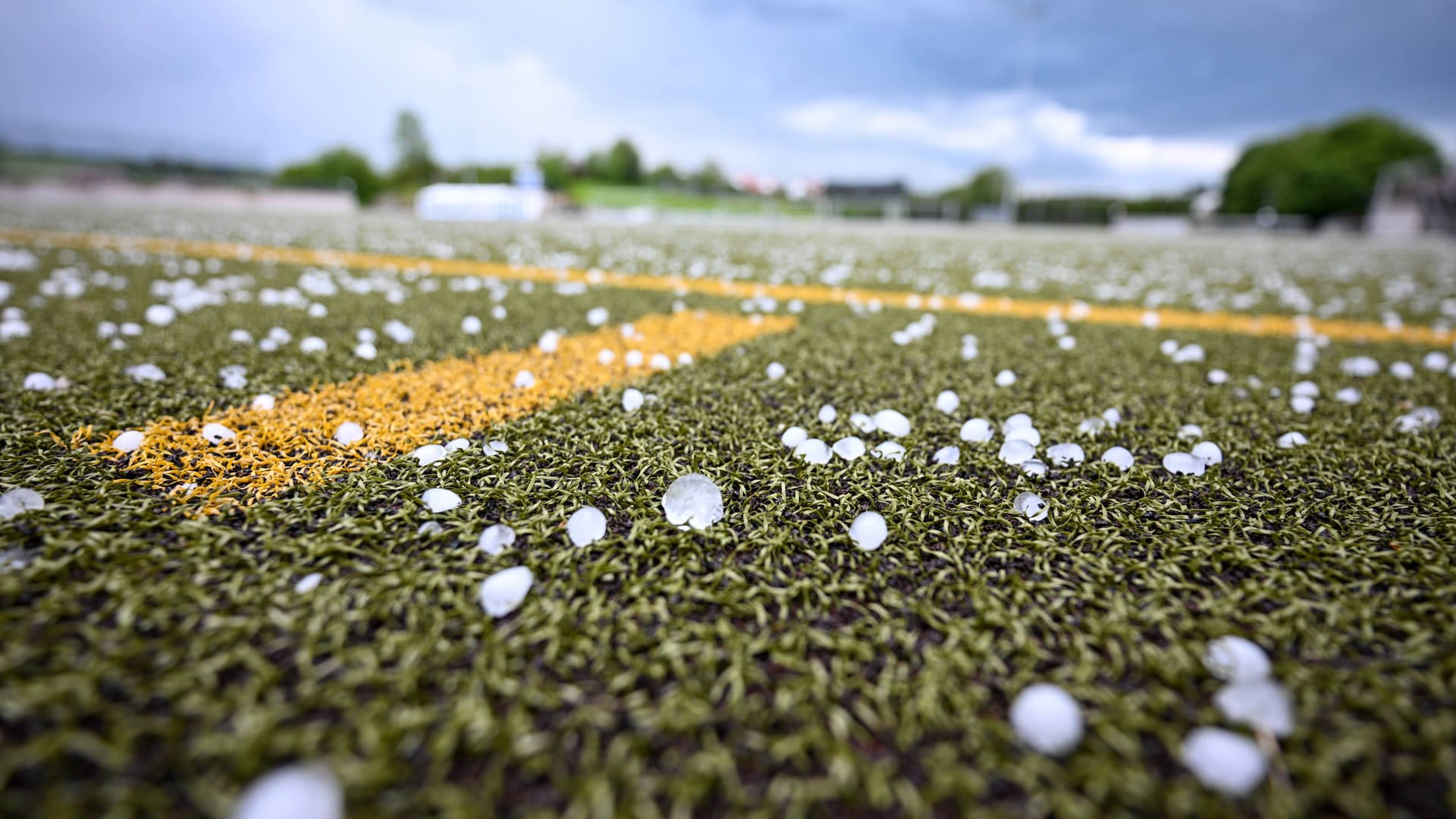 Hagelkörner auf einem Fußballplatz (Symbolbild): Das Wetter gefährdet Public Viewings zum EM-Achtelfinalspiel der deutschen Nationalmannschaft am Samstag.