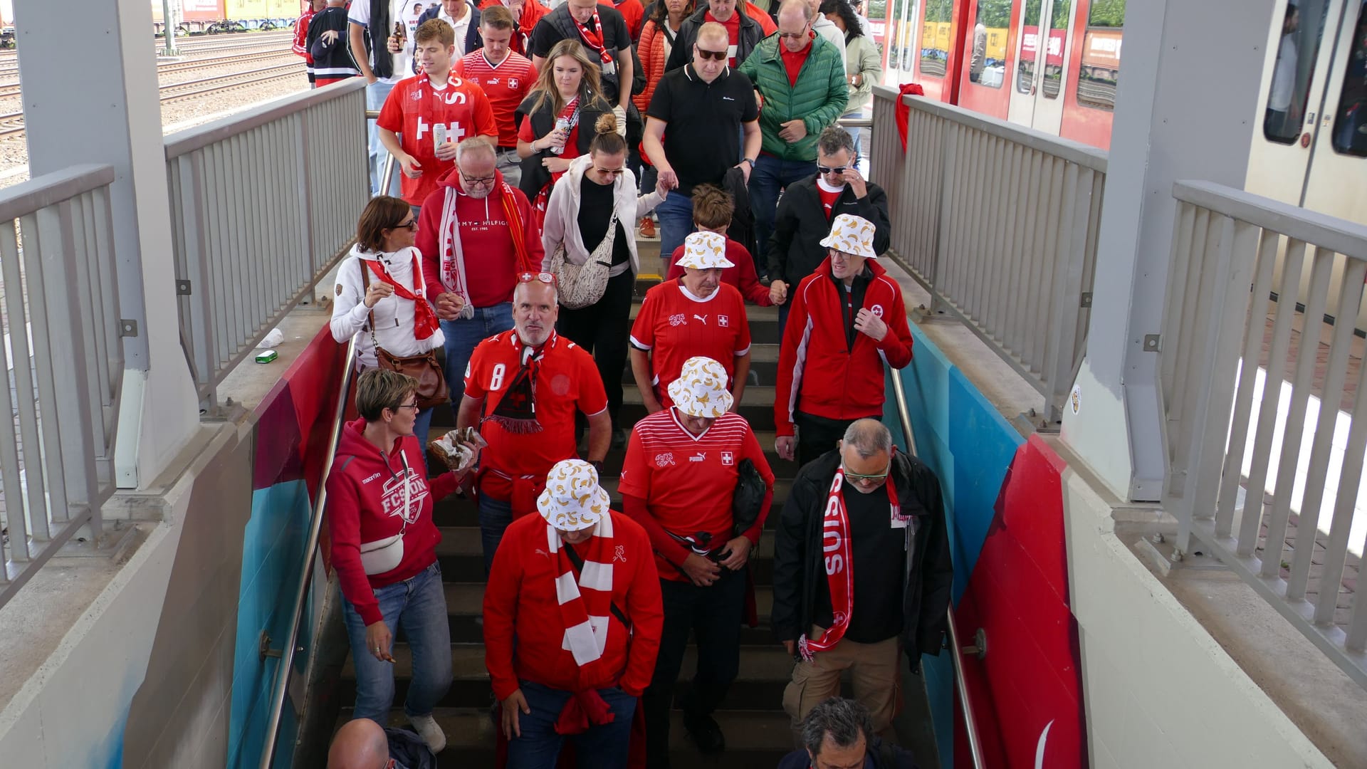 Schweizer Fans kommen am S-Bahnhof Müngersdorf Technologiepark an.