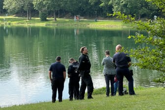 Polizeibeamte stehen am Garchinger See: Dort soll angeblich eine Leiche gefunden worden sein.