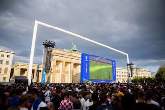 Fans beim Public Viewing in der Fanmeile am Brandenburger Tor (Symbolbild): Am Dienstag drohen in Berlin heftige Gewitter, das Public Viewing könnte ins Wasser fallen.
