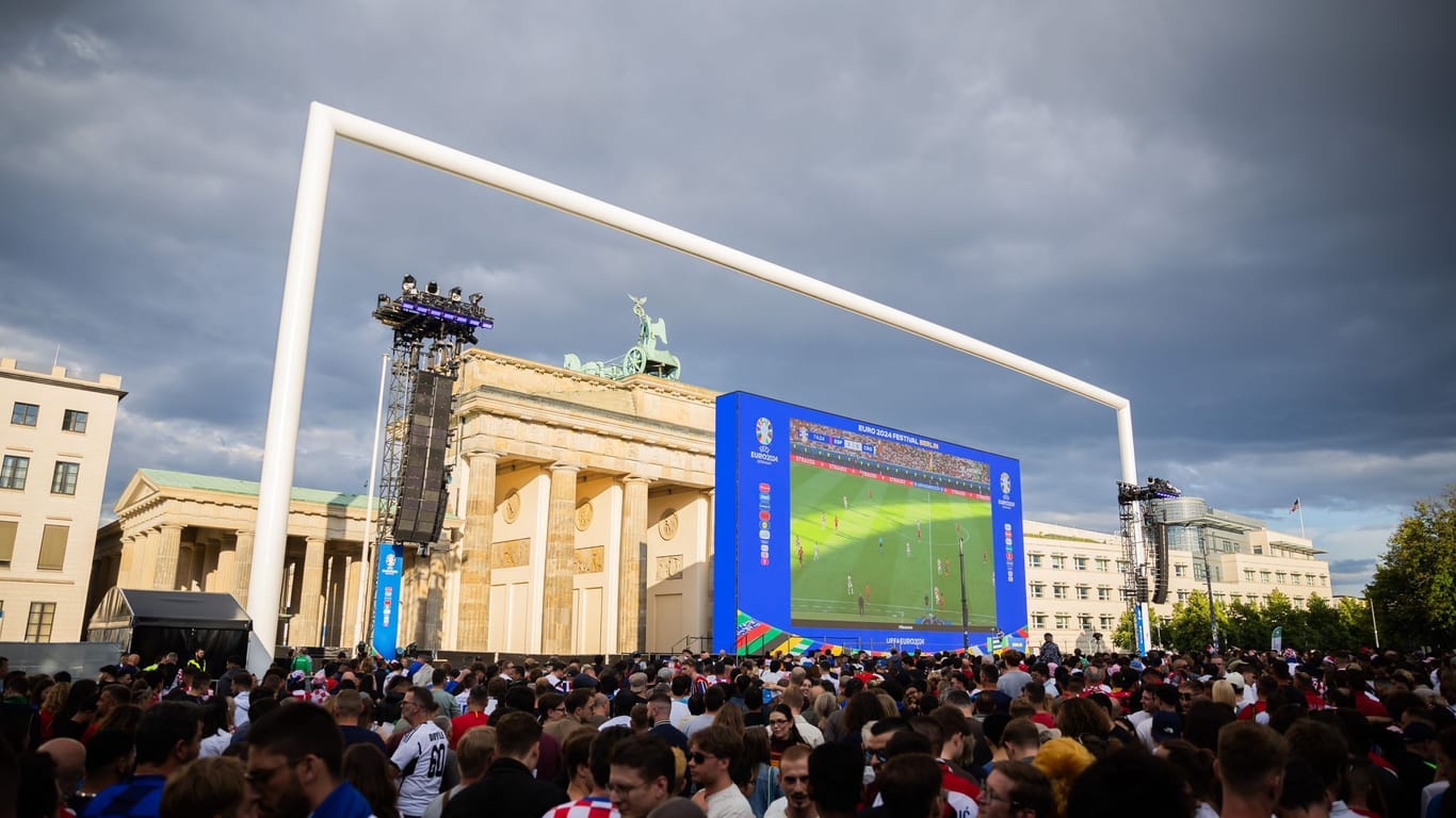 Fans beim Public Viewing in der Fanmeile am Brandenburger Tor (Symbolbild): Am Dienstag drohen in Berlin heftige Gewitter, das Public Viewing könnte ins Wasser fallen.