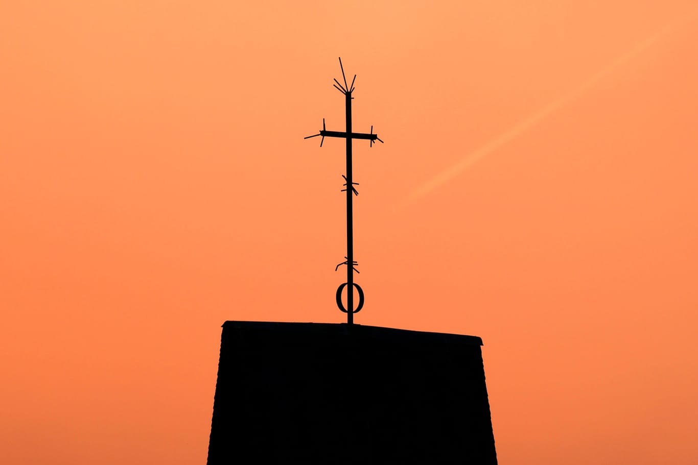 Ein Kreuz steht auf dem Dach einer Kirche vor Abendhimmel (Symbolbild): Die Vorfälle waren durch eine Anzeige der evangelischen Kirche in Bremen bekanntgeworden.