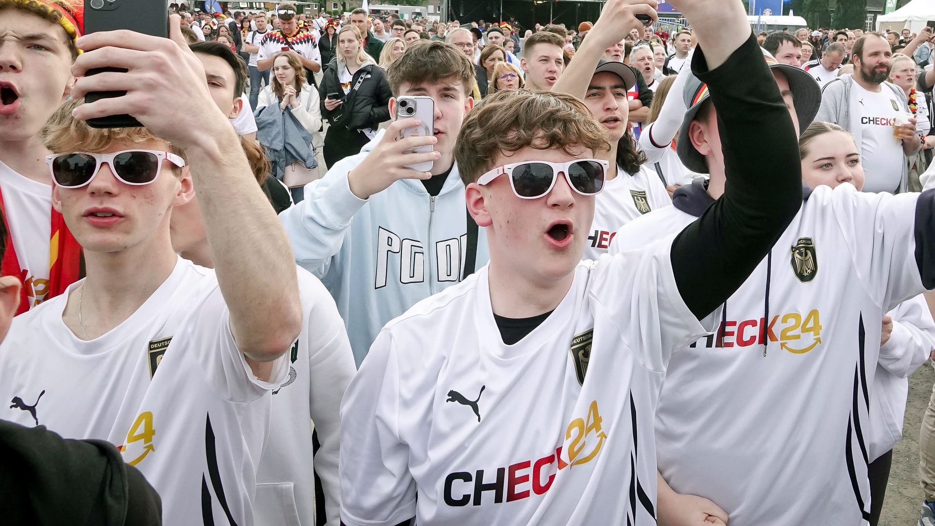 Fanzone in Gelsenkirchen: Deutschland-Fans in Check24-Trikots jubeln.