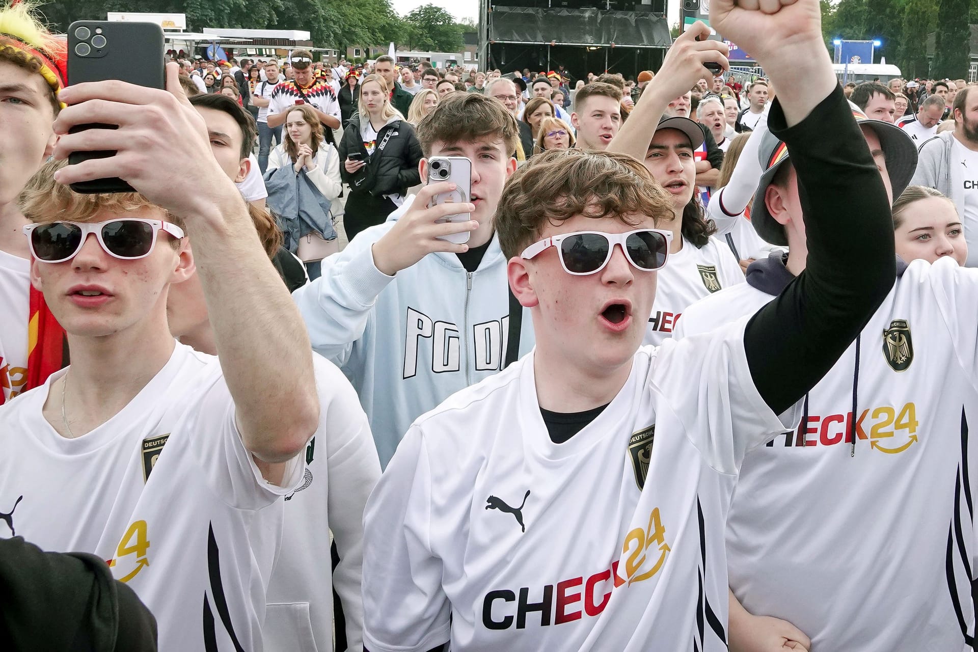 Fanzone in Gelsenkirchen: Deutschland-Fans in Check24-Trikots jubeln.