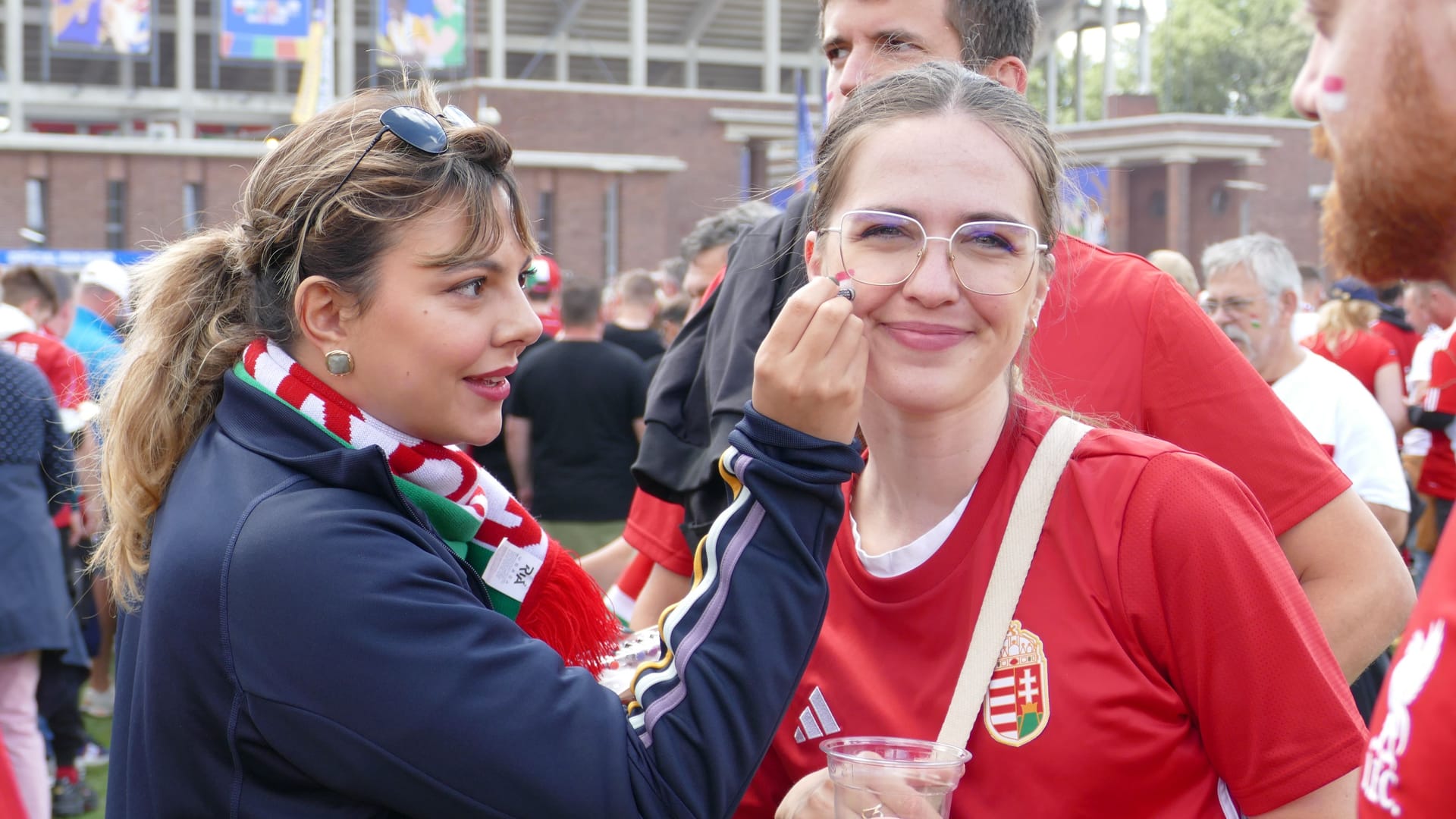 Noch schnell schminken und dann rein: Diese jungen Frauen aus Ungarn bereiten sich auf das Spiel vor.