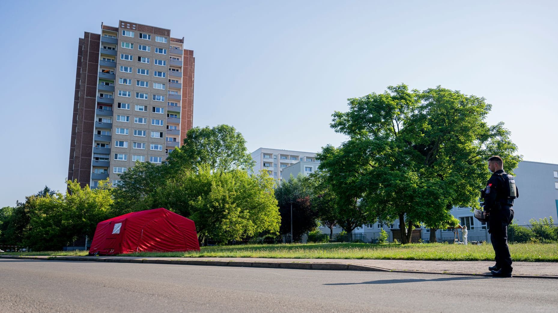 Erfurt: Ein Polizist steht in der Nähe des mutmaßlichen Tatorts an einer Straße. Ein Mann wurde in Erfurt erschossen.