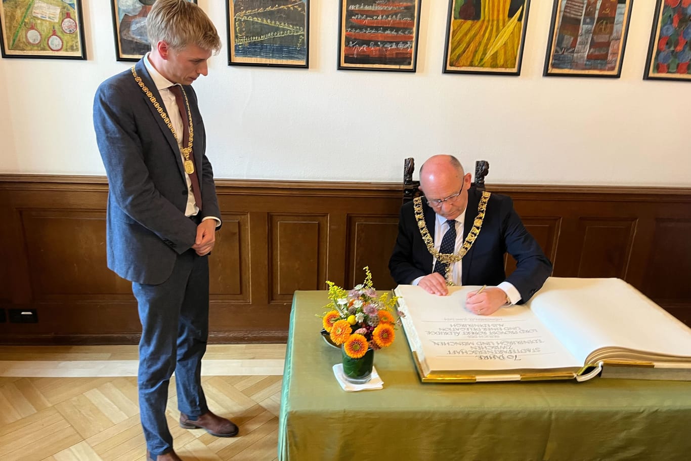 Lord Provost Robert Aldridge (r.) trägt sich in das Goldene Buch Münchens ein: Der zweite Bürgermeister Dominik Krause (l.) hat ihn im Rathaus empfangen.