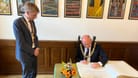 Lord Provost Robert Aldridge (r.) trägt sich in das Goldene Buch Münchens ein: Der zweite Bürgermeister Dominik Krause (l.) hat ihn im Rathaus empfangen.