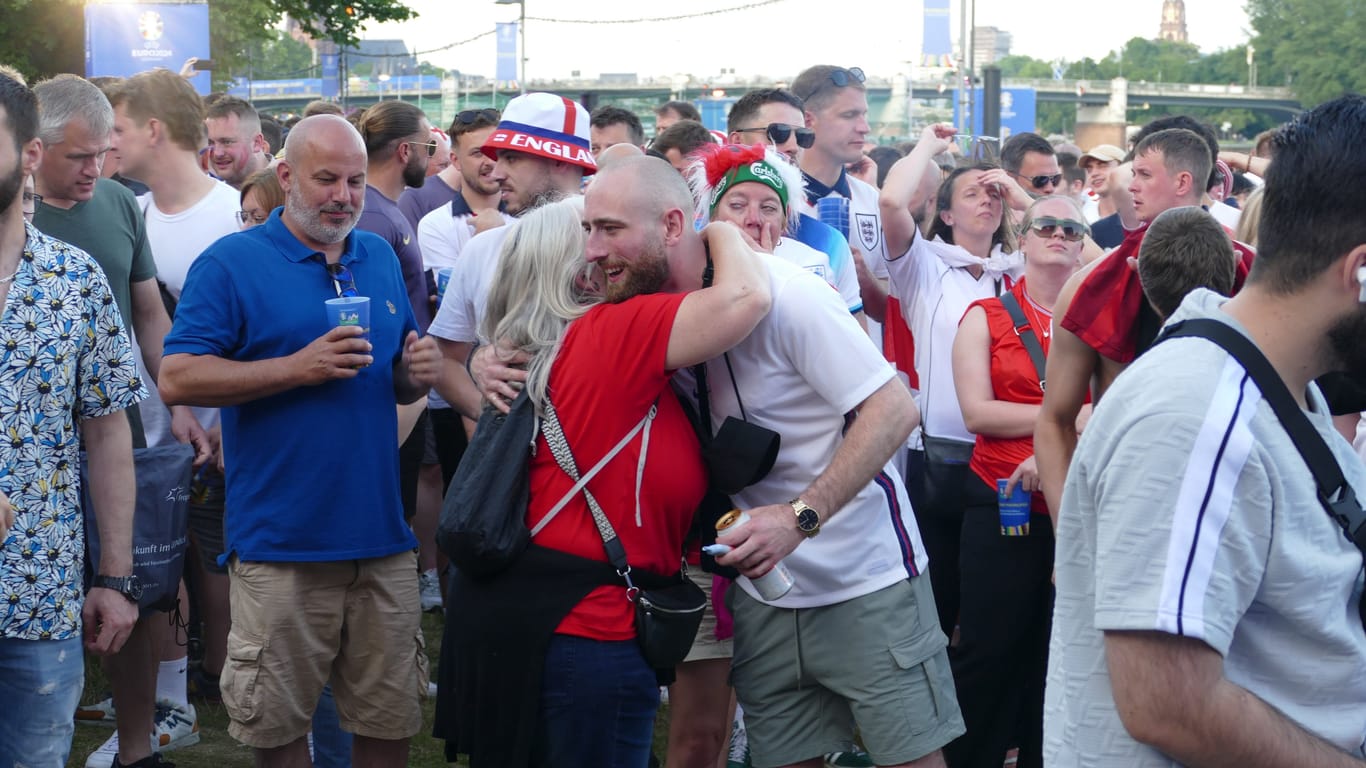 Friedlich vereint in der Fan Zone: Eine dänische Anhängerin umarmt einen englischen Fan nach dem Spiel, das mit einem Unentschieden endete.