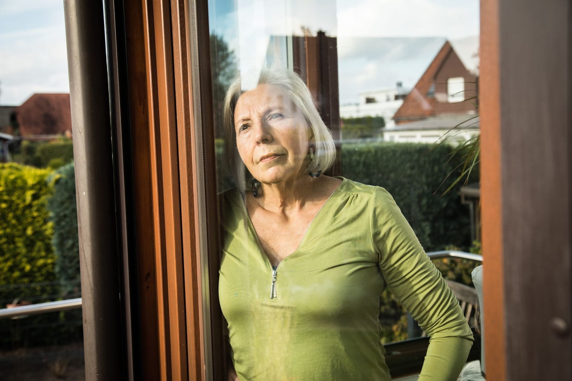 Eine Seniorin blickt aus dem Fenster Eine Seniorin blickt aus dem Fenster
