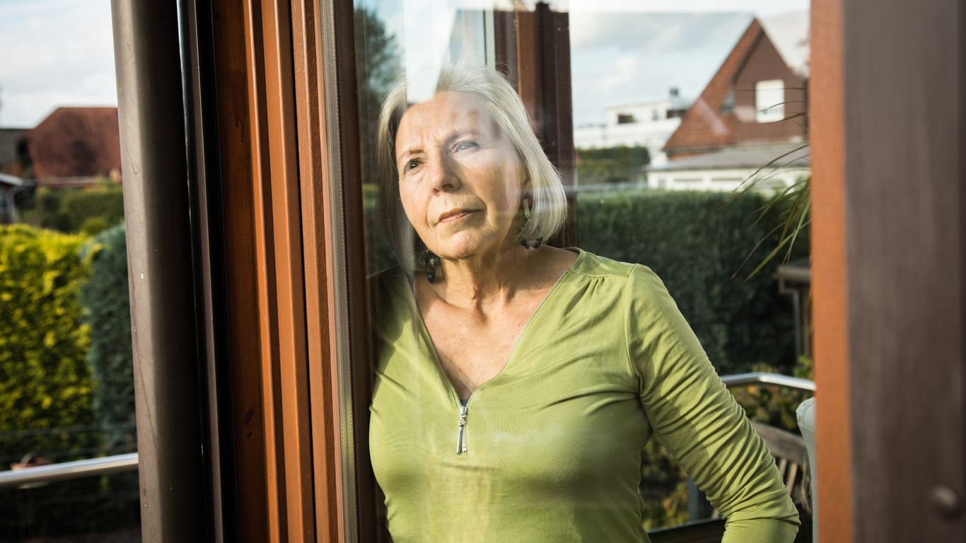 Eine Seniorin blickt aus dem Fenster