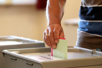 Wähler wirft Wahlumschlag in eine Wahlurne (Symbolbild): Die Auszählung soll bis zum Montagnachmittag abgeschlossen sein.