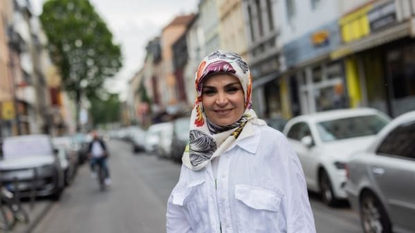 Meral Sahin, Vorsitzende der IG Keupstraße, steht in der Keupstraße.