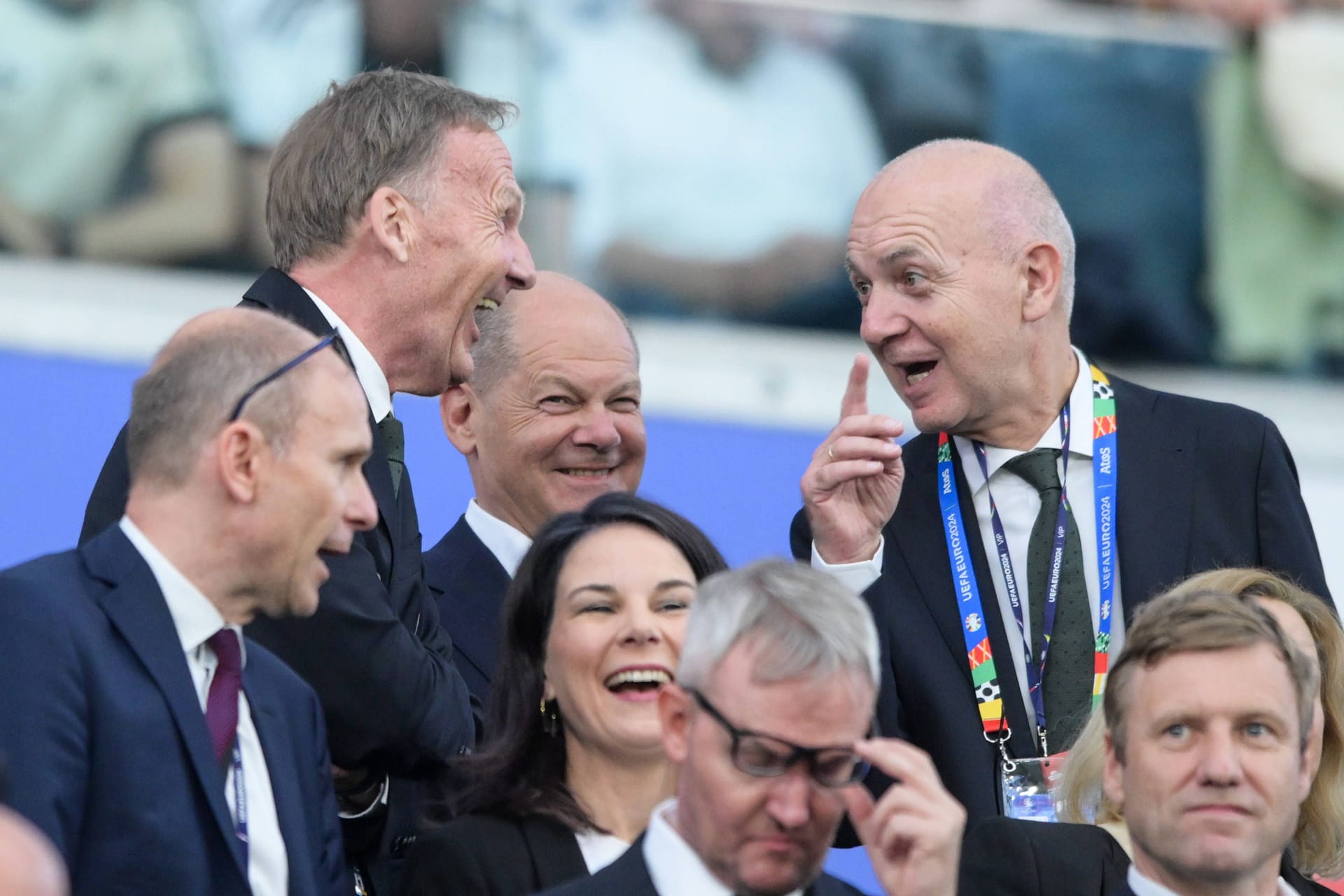 Bundeskanzler Olaf Scholz bei Spiel Schweiz - Deutschland auf der Tribüne: Vor ihm lachen Hans-Joachim Watzke(l.) und Bernd Neuendorf.