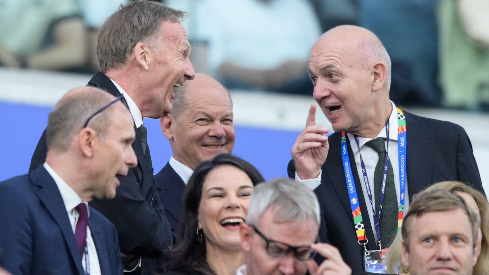 Bundeskanzler Olaf Scholz bei Spiel Schweiz - Deutschland auf der Tribüne: Vor ihm lachen Hans-Joachim Watzke(l.) und Bernd Neuendorf.