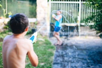 Kinder spielen mit Wasserpistolen (Archivbild): Der Spielzeugwaffeneinsatz löste in Baden-Württenberg während der Europawahl einen Polizeieinsatz aus.