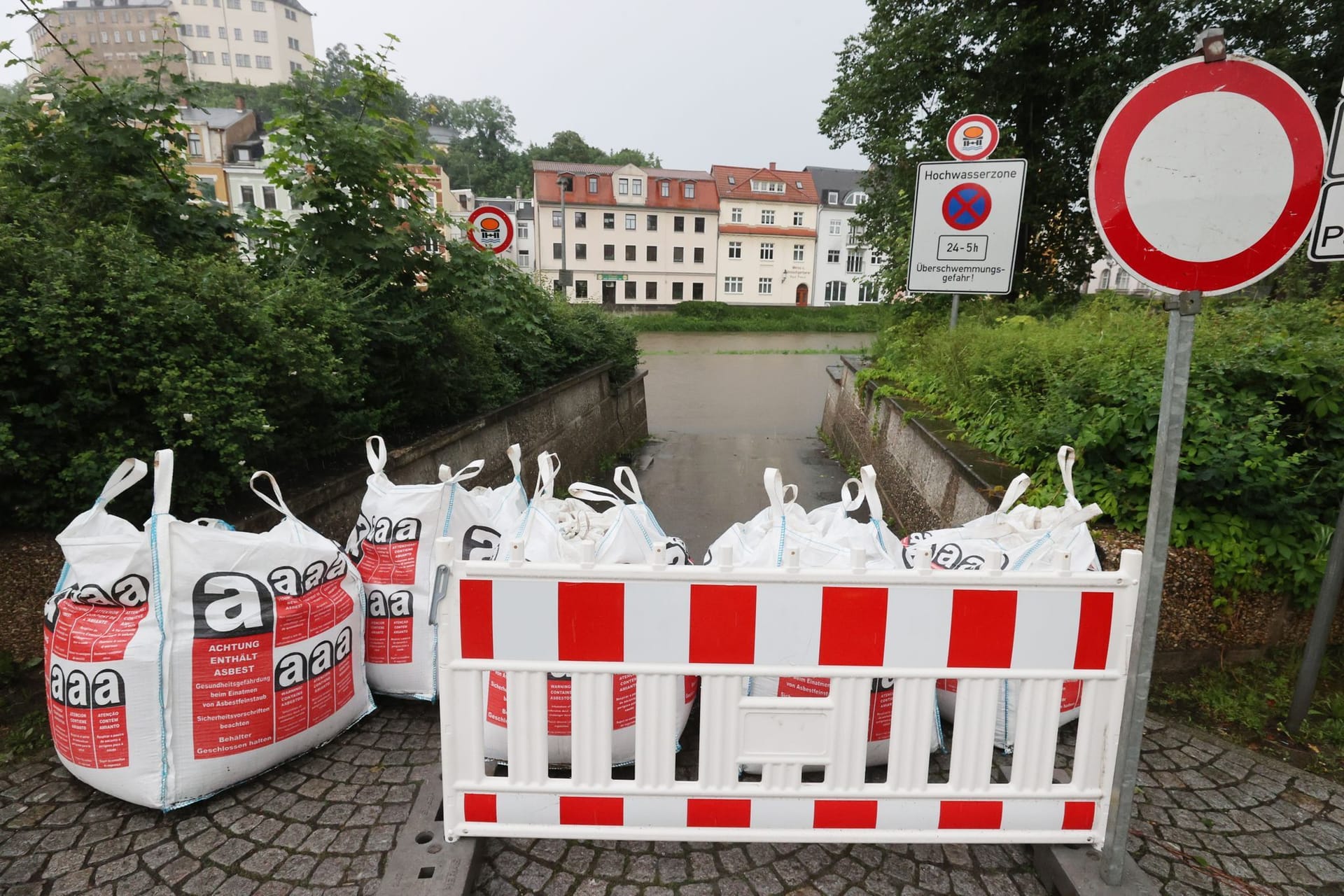 Thüringen, Greiz: Die Zufahrt zu einem Parkplatz am Ufer des Flusses "Weiße Elster" ist mit Sandsäcken gesperrt.