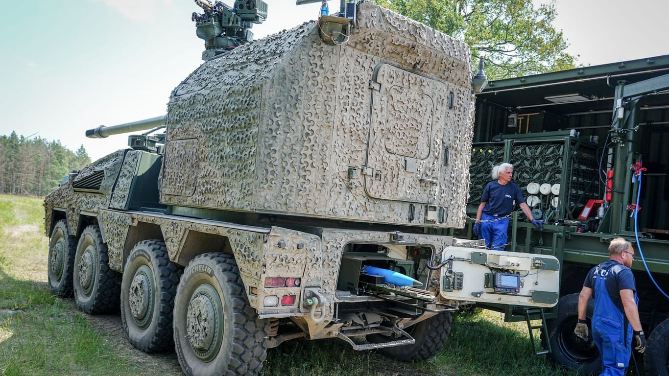 Mitarbeiter von KNDS beladen eine neue Radhaubitze RCH 155 des Panzerherstellers mit Munition.