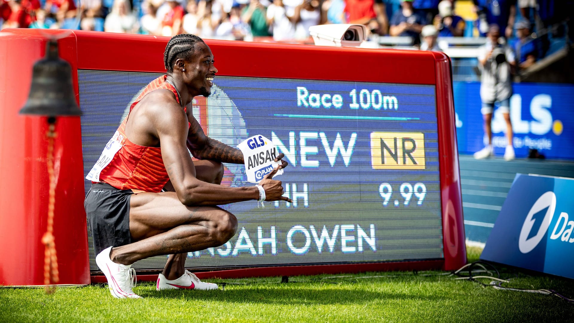 Owen Ansah neben der Anzeige mit seinem neuen Rekord.