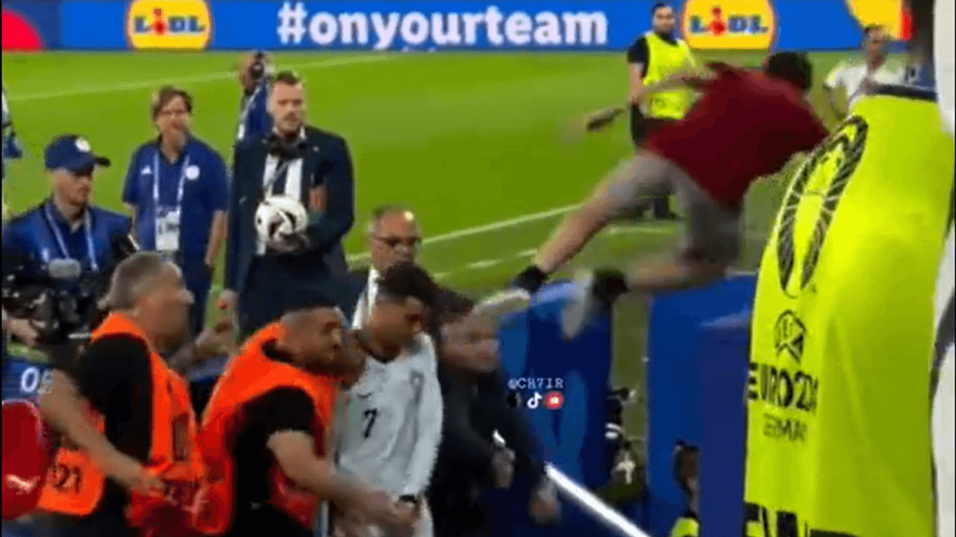 Screenshot des Sprungs: Der Mann in Rot will vor die Füße von Cristiano Ronaldo springen. Er springt ihm aber fast auf den Kopf.