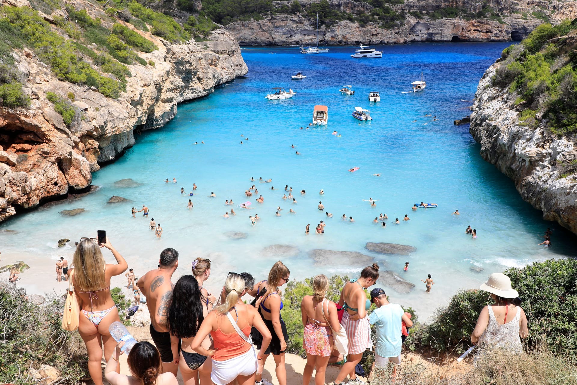 Menschen stehen Schlange am Strand Calo des Moro in Mallorca (Archivbild): Der Massentourismus zerstört die Natur vor Ort.