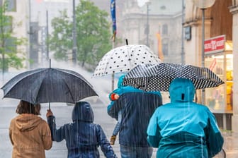 Menschen laufen bei Regen über den Stachus (Archivbild): Noch kann der DWD nicht genau sagen, wo es zu den Unwettern kommt.