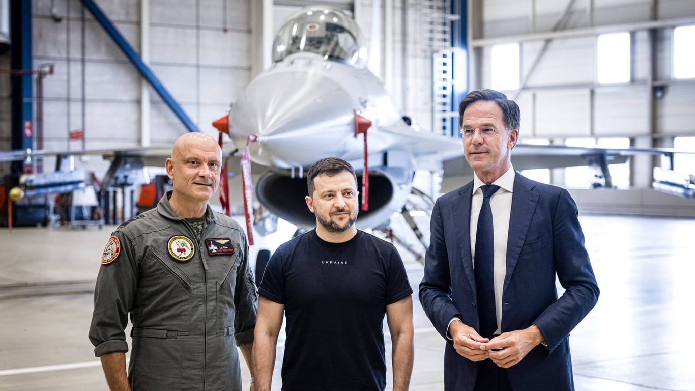 Volodymyr Selenskyj (Mitte) mit dem niederländischen Premierminister Martin Rutte (rechts) vor einem F-16 Kampfjet.
