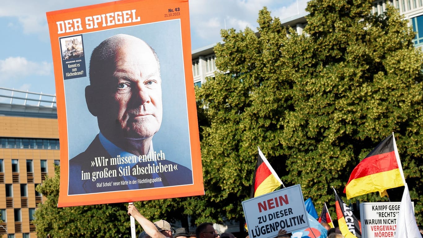 Demo in Mannheim: Ein Demonstrant hält ein Plakat in die Luft.