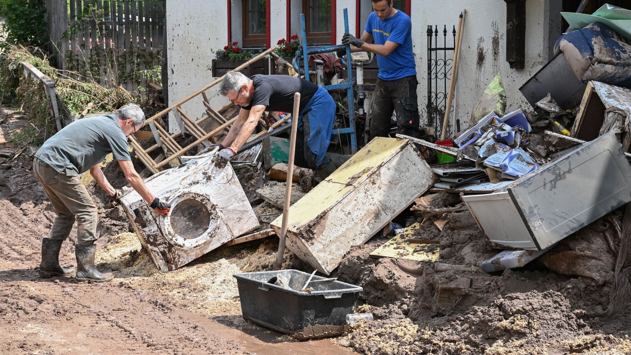 Baden-Württemberg, Klaffenbach: Helfer bergen Gegenstände, die durch ein Hochwasser nach einem Unwetter zerstört wurden.