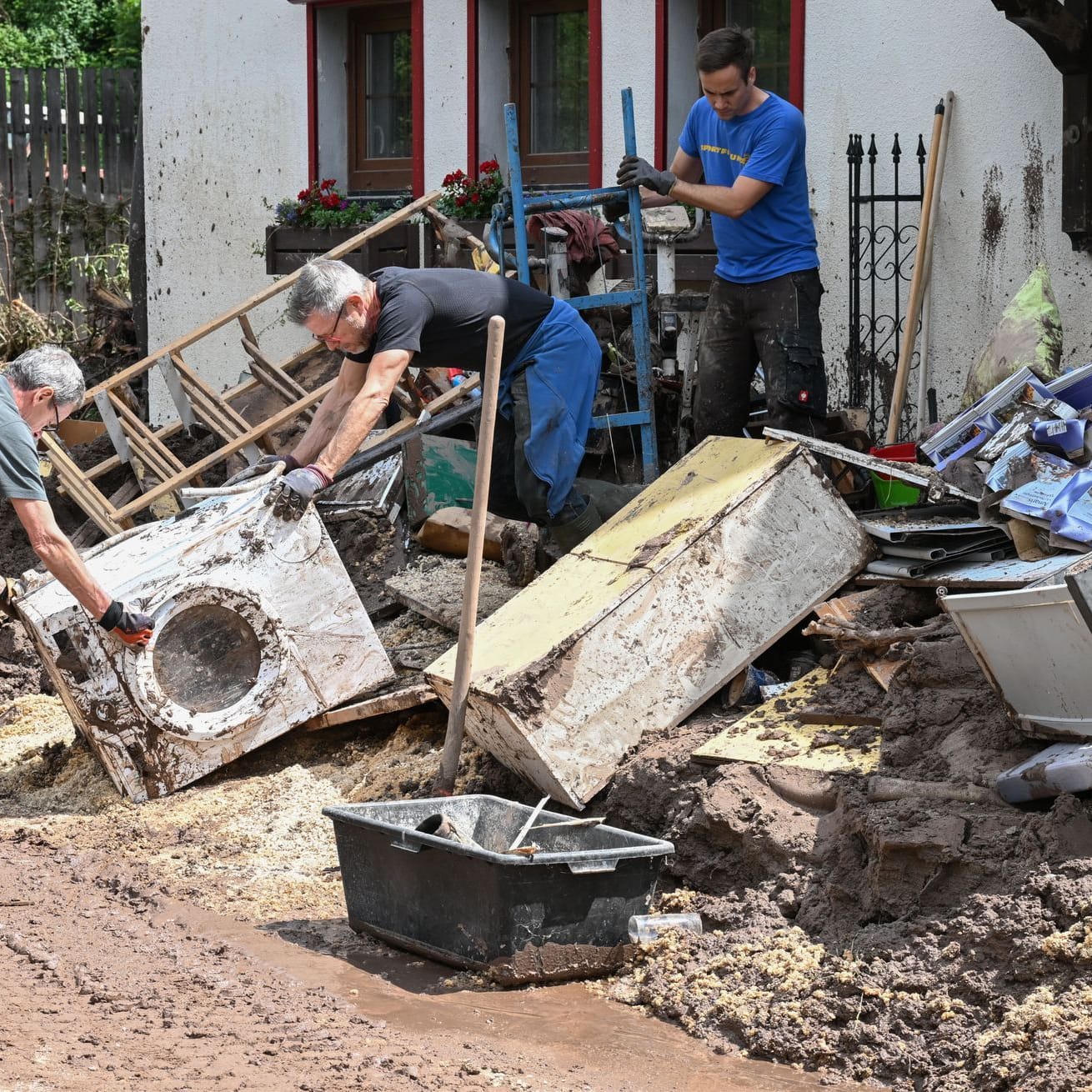 Baden-Württemberg, Klaffenbach: Helfer bergen Gegenstände, die durch ein Hochwasser nach einem Unwetter zerstört wurden.