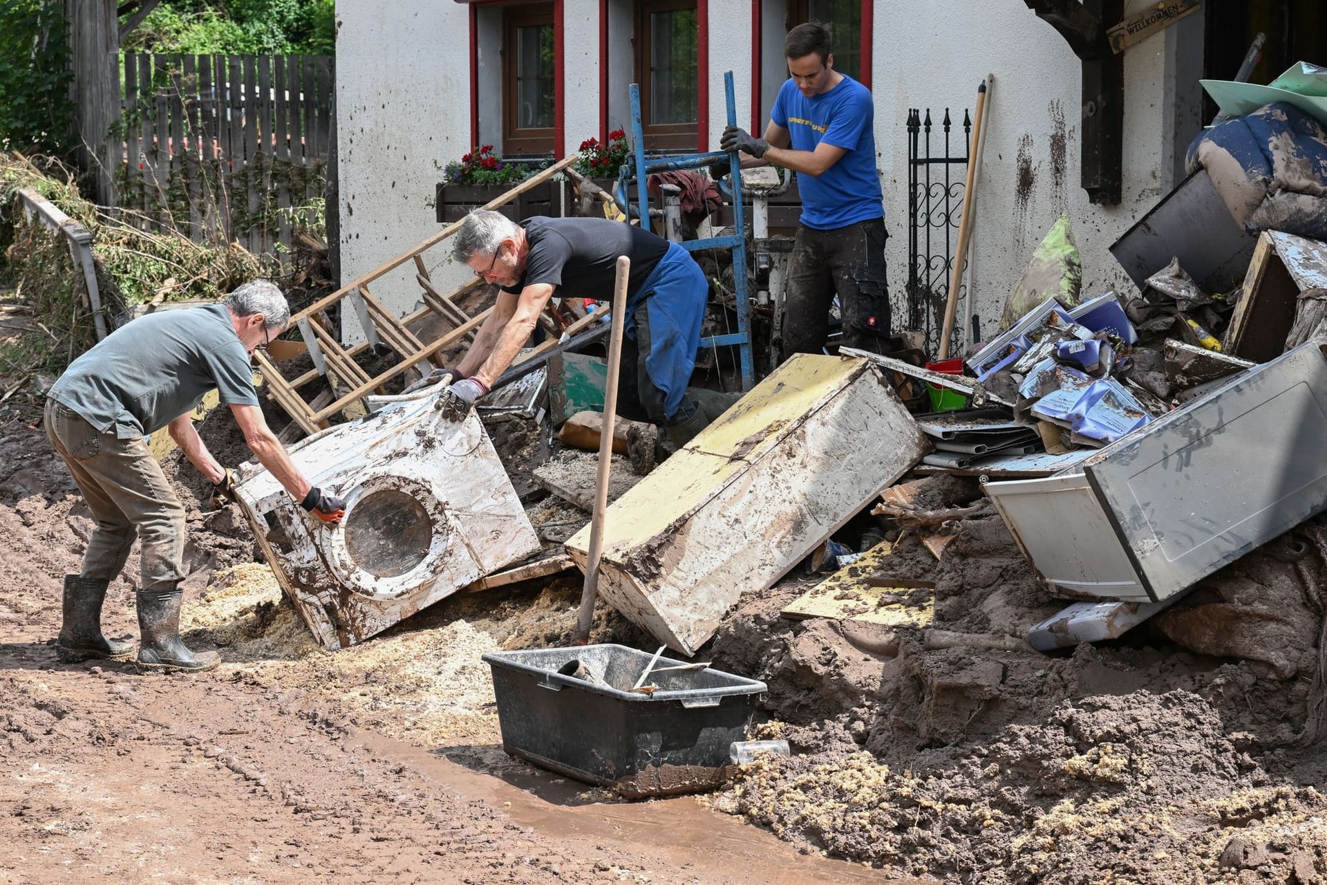 Baden-Württemberg, Klaffenbach: Helfer bergen Gegenstände, die durch ein Hochwasser nach einem Unwetter zerstört wurden.