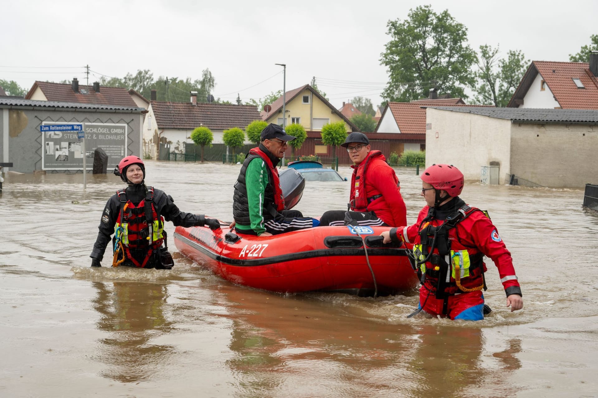 Wasserretter bergen Bewohner aus einem überschwemmten Haus.